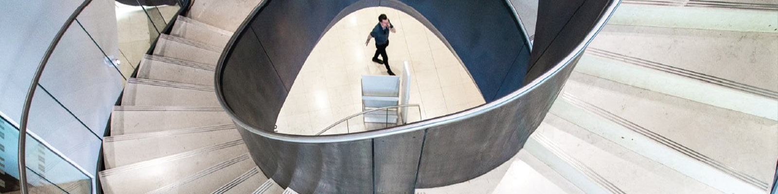 Man walking up the spiral staircase